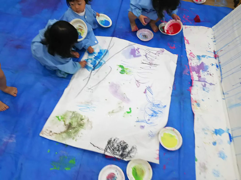 いろんな色の絵の具でペイントする子どもたち